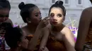 Penari wanita muda mempersiapkan diri untuk tampil pada perayaan Hari Raya Kuningan di Pura Sakenan, Bali, Sabtu (18/6/2022). Kuningan menandai hari terakhir perayaan Galungan, salah satu upacara keagamaan terbesar umat Hindu di Bali. (AP Photo/Firdia Lisnawati)