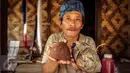 Seorang warga Baduy Luar menunjukan gula aren yang dibungkus daun dan telah dibuka untuk siap dikonsumsi di Kampung Kadu Jangkung, Kabupaten Lebak, Banten (12/05). Gula aren tersebut digunakan sebagai dasar pembuatan makanan. (Liputan6.com/Fery Pradolo)