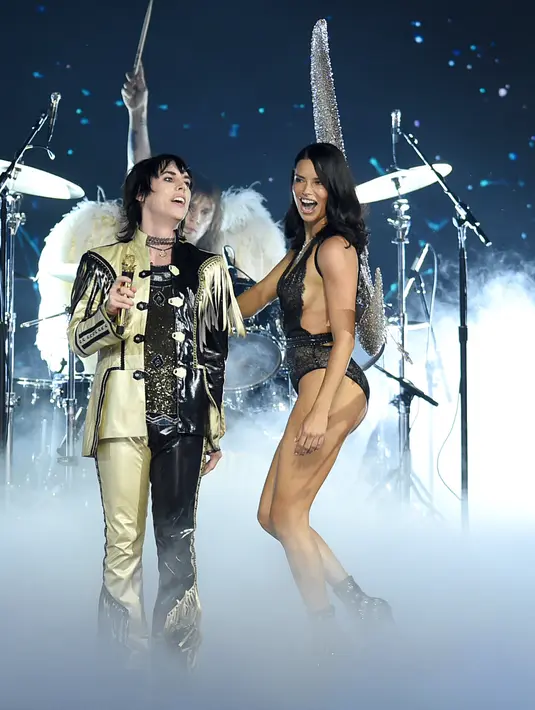 Penyanyi Luke Spiller of The Struts (kiri) bernyanyi bersama model Adriana Lima (kanan) saat tampil di panggung Victoria's Secret Fashion Show 2018 di Pier 94, New York, AS, Kamis (8/11). (Photo by Evan Agostini/Invision/AP)