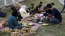 Relawan menyiapkan makanan dan buah untuk dibagikan kepada orang-orang yang berbuka puasa di pinggir jalan di Islamabad, Pakistan, 5 April 2022. Umat Muslim di seluruh dunia menjalankan Ramadhan, di mana mereka menahan diri dari makan, minum, merokok dan seks dari fajar hingga senja. (AP/Rahmat Gul)