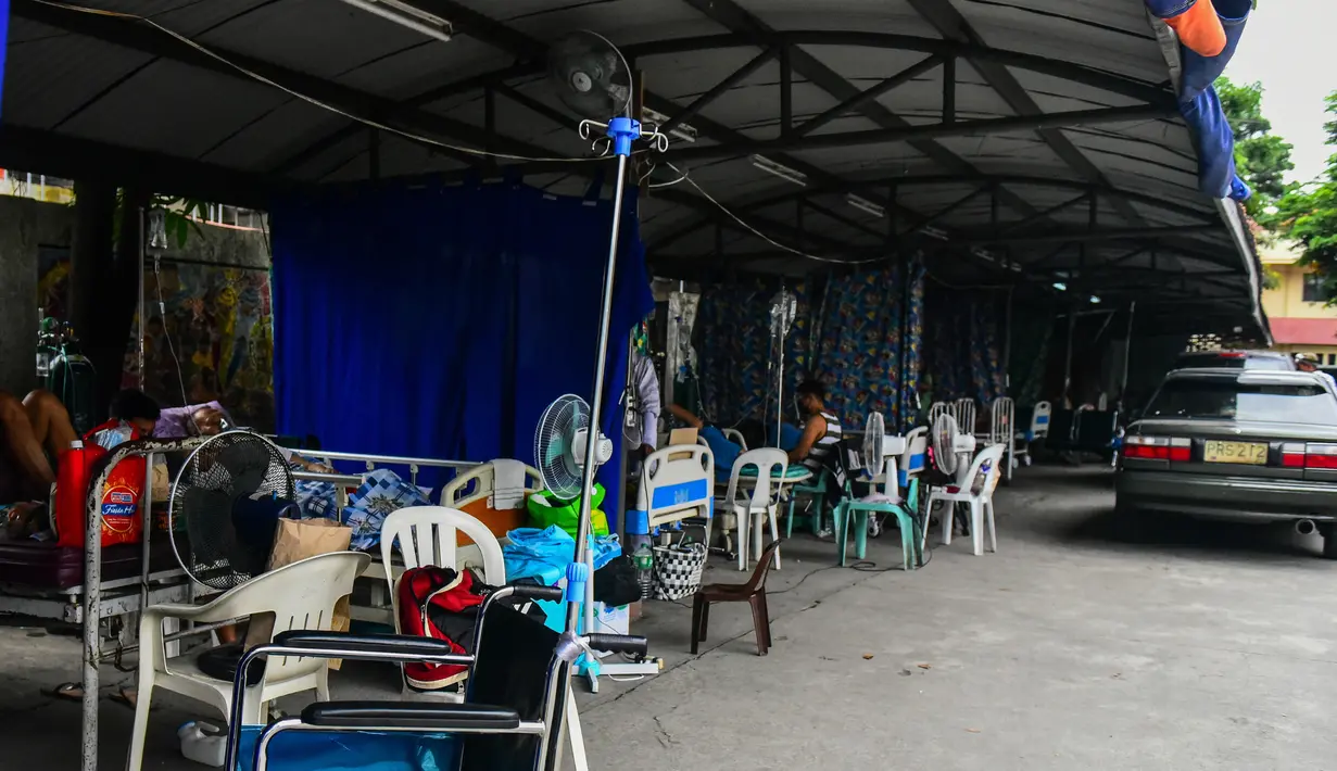 Pasien yang terduga Covid-19 beristirahat di tempat parkir yang diubah menjadi bangsal di luar rumah sakit di kota Binan, provinsi Laguna, Manila, di tengah rekor infeksi yang dipicu oleh varian Delta yang sangat menular pada Senin (6/9/2021). (Photo by Maria Tan / AFP)