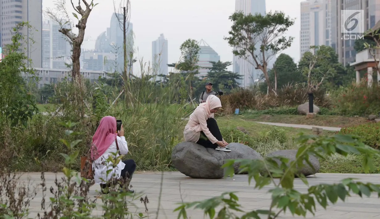 Warga menyalurkan hobi fotografi di area Hutan Kota Gelora Bung Karno, Jakarta, Kamis (20/6/2019). Sore hari banyak warga memanfaat waktu luang dengan berolahraga dan menyalurkan hobi fotografi di area Hutan Kota Gelora Bung Karno. (Liputan6.com/Helmi Fithriansyah)