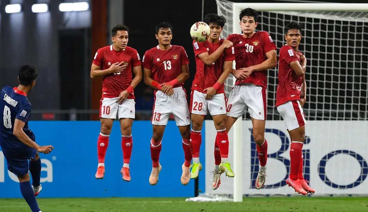 Gelandang Timnas Singapura, Shahdan Sulaiman (kiri) melakukan tendangan bebas untuk mencetak gol pada pertandingan leg kedua semifinal Piala AFF 2020 di National Stadium, Sabtu (25/12/2021). Laga dimenangkan Indonesia 4-2 lewat perpanjangan waktu 2 x 15 menit. (AFP/Roslan Rahman)