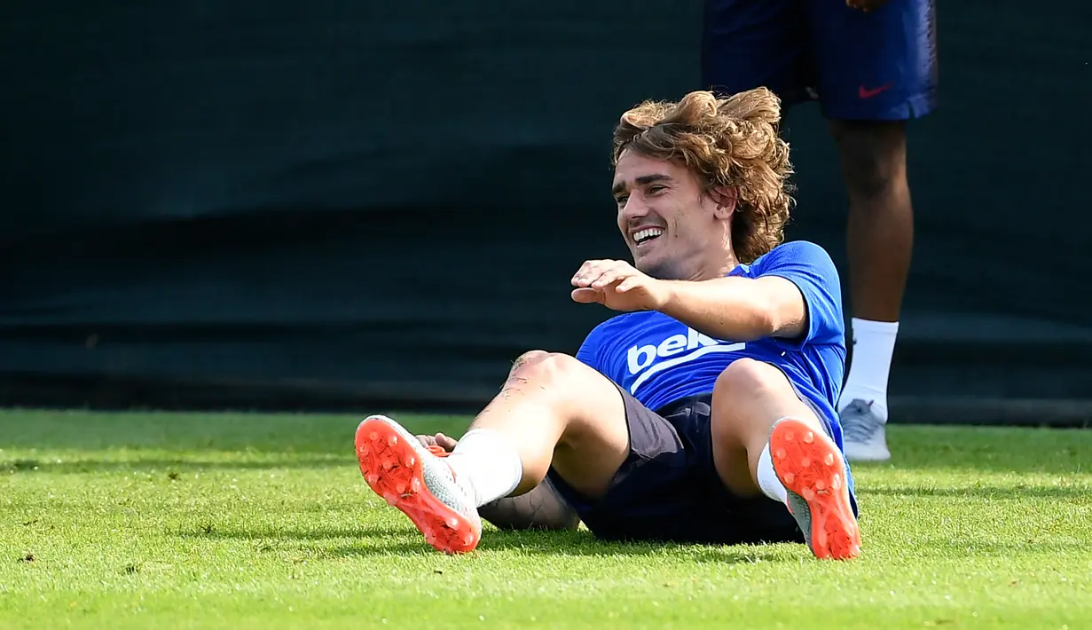 Penyerang baru Barcelona, Antoine Griezmann tertawa ketika mengikuti latihan di Joan Gamper, Barcelona (15/7/2019). Griezmann dibeli Barcelona dengan mahar 120 juta euro atau senilai Rp 1,8 triliun dari Atletico Madrid. (AFP Photo/Lluis Gene)