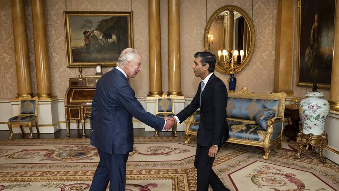 Raja Charles III menyambut Rishi Sunak selama audiensi di Istana Buckingham, London, di mana ia mengundang pemimpin Partai Konservatif yang baru terpilih untuk menjadi Perdana Menteri dan membentuk pemerintahan baru, Selasa, 25 Oktober 2022. (Aaron Chown/Pool photo via AP)