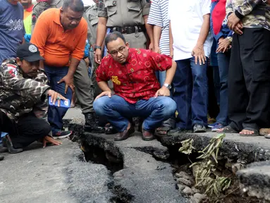 Gubernur DKI Anies Baswesdan meninjau lokasi jalan retak di  Kelurahan Kebon Manggis, Kecamatan Matraman, Jakarta Timur, Jumat (16/2). Anies melihat upaya petugas melakukan perbaikan jalan yang membuat akses kendaraan terputus. (Liputan6.com/Johan Tallo)