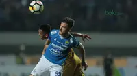 Pemain Persib Bandung, Jonathan Bauman berebut bola dengan pemain Mitra Kukar, Hendra Bayauw pada laga Liga 1 Indonesia di GBLA, (8/4/2018). (Bola.com/Nick Hanoatubun)