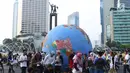 Replika bola dunia berukuran besar digelindingkan di sekitar kawasan Bundaran HI, Jakarta, Minggu (16/9). Acara ini bagian dari peringatan Hari Ozon Sedunia 2018 dengan tema Keep Cool and Carry on! The Montreal Protocol. (Liputan6.com/Helmi Fithriansyah)