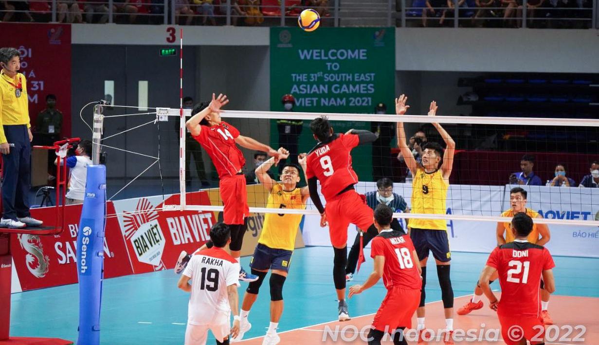 Pemain Timnas Voli Putra Indonesia, Farhan Halim (kiri) melakukan spike ke arah pemain Timnas Vietnam pada laga final SEA Games 2021 yang berlangsung di Dai Yan Sports Arena, Quang Ninh Vietnam, Minggu, 22 Mei 2022. Skuat asuhan Jiang Jie berhasil menang telak dengan skor 3-0 (25-22, 25-18, dan 25-15). (Foto: NOC Indonesia/MP Media/Gilang Riandi)