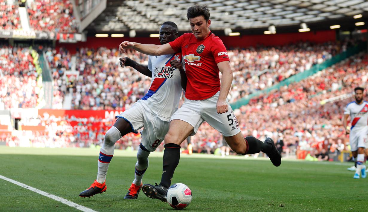 Pemain Crystal Palace Cheikhou Kouyate (kiri) dan pemain Manchester United (MU) Harry Maguire berebut bola saat bertanding dalam Liga Inggris di Old Trafford, Manchester, Inggris, Sabtu (24/8/2019). MU kalah dari Crystal Palace dengan skor 1-2. (AP Photo/Alastair Grant)
