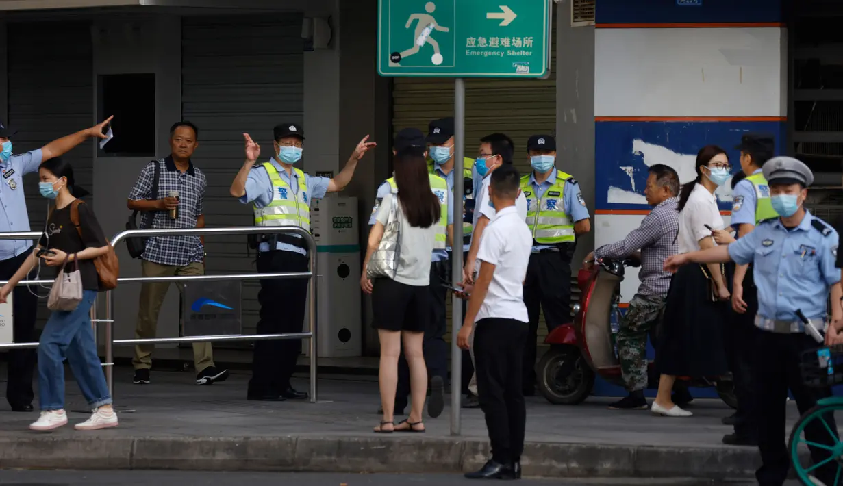 Polisi China mengarahkan warga menjauh dari lingkungan yang ditutup sebelum penutupan resmi Konsulat Amerika Serikat di Chengdu, Senin (27/7/2020). Bendera Amerika Serikat di Konsulat AS Chengdu diturunkan, menandai ditutupnya kantor perwakilan Negeri Paman Sam di kota itu. (AP Photo/Ng Han Guan)