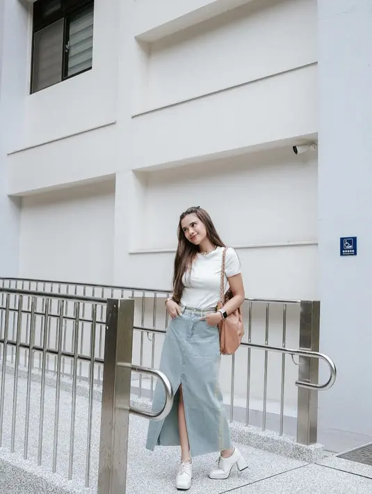 Kali ini, Audi Marissa memancarkan pesona bak anak kuliahan. Ia tampak menawan dengan kaus putih rok denim asimetris dan high heel boots warna senada dengan atasannya. [@audimarissa]