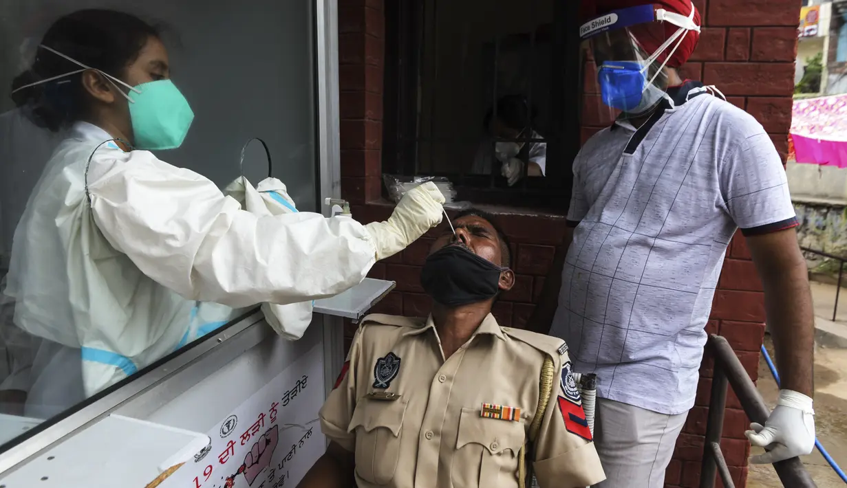 Petugas kesehatan mengambil sampel swab seorang pria untuk menguji virus corona Covid-19 di sebuah rumah sakit di Amritsar (2/9/2020). (AFP/Narinder Nanu)