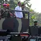 Presiden Joko Widodo saat menaiki Panser Anoa ditemani panglima TNI Jenderal Moeldoko dan Para Kepala Kesatuan jelang upacara pengangkatan dirinya sebagai warga kehormatan pasukan khusus TNI, Kamis (16/4/2015). (Liputan6.com/Yoppy Renato)