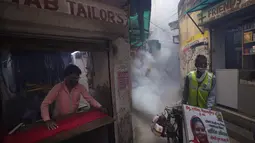 Pekerja kota melakukan fogging atau pengasapan daerah padat penduduk di New Delhi, India, Rabu (27/10/2021). New Delhi telah melaporkan ratusan kasus demam berdarah, dengan lebih dari 200 kasus baru dalam seminggu terakhir, menurut laporan yang dirilis pada hari Senin. (AP Photo/Manish Swarup)