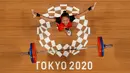 Foto yang diambil dengan kamera robot ini menunjukkan reaksi Windy Cantika Aisah dari Indonesia saat berlaga dalam kompetisi angkat besi 49kg putri pada Olimpiade Tokyo 2020 di Tokyo International Forum, Tokyo pada 24 Juli 2021. (AFP/Pool/Chris Graythen)