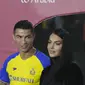 Cristiano Ronaldo menatap sang kekasih Georgina Rodriguez saat mereka menghadiri upacara penyambutan dirinya sebagai pemain baru Al Nassr di Stadion Mrsool Park, di ibu kota Saudi, Riyadh, Selasa (3/1/2023). Kekasih CR7 yang biasanya kerap memamerkan kemolekan tubuhnya terlihat lebih sopan dalam berpakaian. (AP Photo/Amr Nabil)