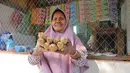 Ragaia Sosir menunjukkan terasi yang dijual di kiosnya. Sebelum membuka kios dan menjadi BRILink Agen, ia mengandalkan hasil melaut bersama suami dan mengolah udang menjadi terasi untuk menambah penghasilan keluarga. (Sumber: BRI/Advertorial)
