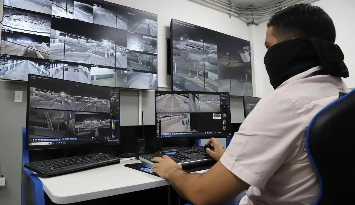 Seorang pegawai Direktorat Jenderal Penjara bekerja di ruang pengawasan video saat tur media di Pusat Pengurungan Terorisme, Tecoluca, El Salvador, 2 Februari 2023. Menurut pemerintah, penjara besar yang masih dalam pembangunan tersebut memiliki kapasitas maksimum 40.000 narapidana dan dimaksudkan untuk memenjarakan anggota geng. (AP Photo/Salvador Melendez)