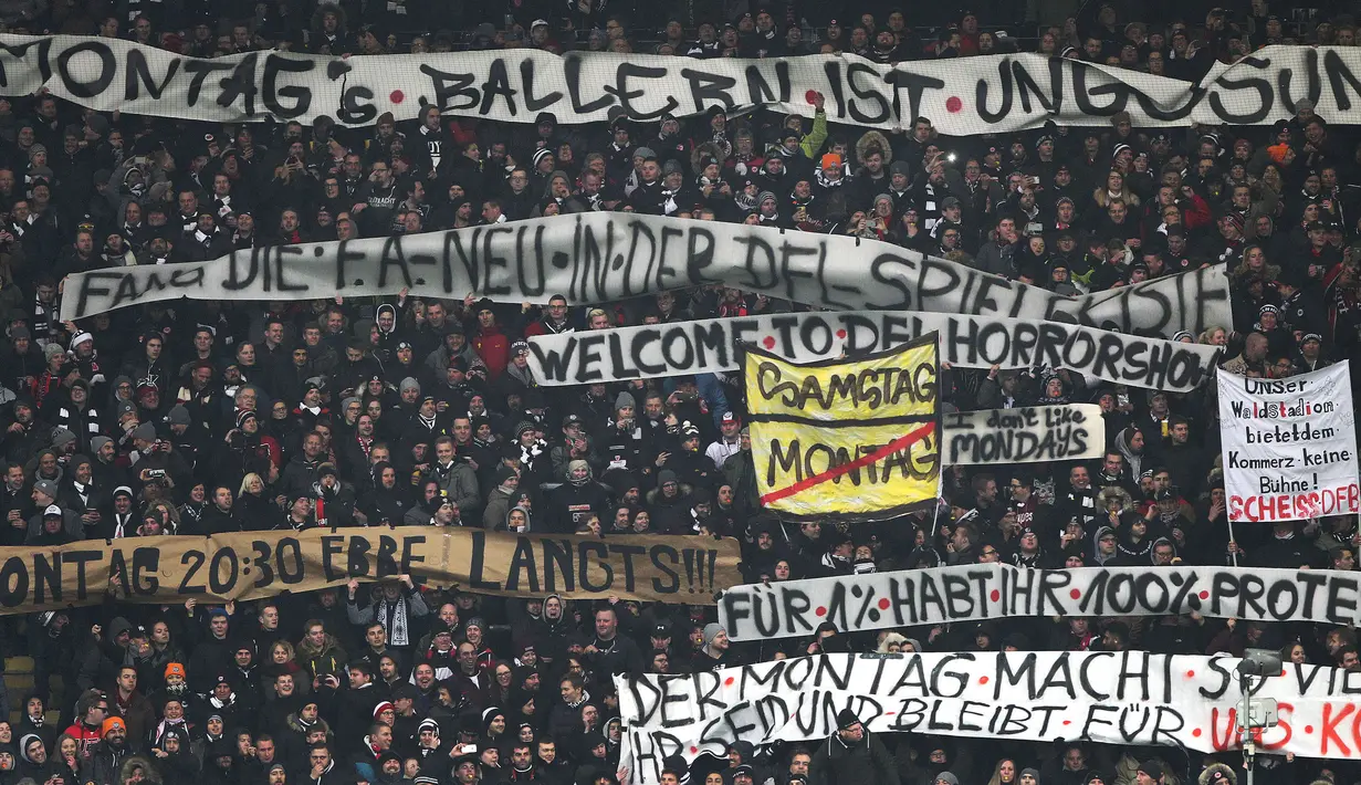 Ratusan penggemar membentangkan spanduk-spanduk yang berisi pesan-pesan seperti 'Tidak untuk sepak bola Senin malam' saat Kick-off  laga Eintracht Frankfurt vs RB Leipzig di Stadion Commerzbank Arena, Senin (19/2). (DANIEL ROLAND/AFP)