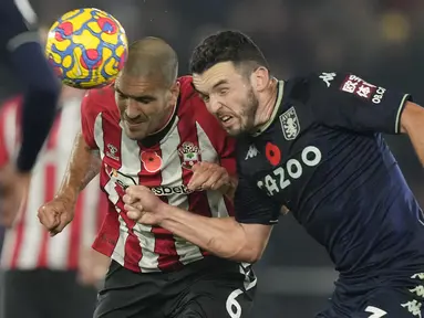 Gelandang Southampton Oriol Romeu melakukan sundulan saat berebut bola dengan gelandang Aston Villa John McGinn pada laga lanjutan Liga Inggris 2021-2022 di Stadion St Mary’s, Sabtu (6/11/2021) dini hari WIB. Southampton tekuk Aston Villa 1-0. (AP Photo/Frank Augstein)