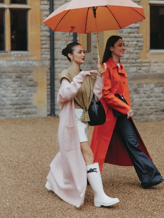 Sama-sama kenakan long coat, Yasmin Napper dan Amanda Rawles tampil dengan look yang kontras. Yasmin terlihat lebih edgy dengan paduan inner putih dan celana lebar. Sedangkan Amanda padukan atasan cokelat berkerut dengan rok mini dan boots [@amandarawles]