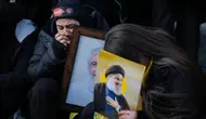 Para pelayat memegang foto Nasrallah, kanan, dan Safieddine dalam prosesi pemakaman [Bilal Hussein/AP]