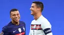 Striker Prancis, Kylian Mbappe, tersenyum kepada striker Portugal, Cristiano Ronaldo, pada laga UEFA Nations League di Stadion Stade de France, Senin (12/10/2020). Kedua tim bermain imbang 0-0. (AFP/Franck Fife)
