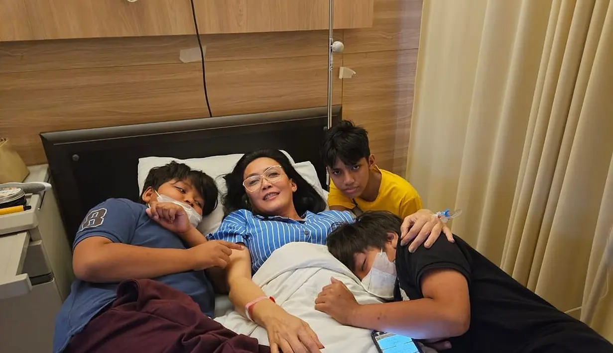 Rieke tampak tiduran di ranjang rumah sakit dikelilingi tiga anaknya. "Tiga lelaki, padaku cinta tanpa syarat, sabar tanpa tepi. Terima aku apa adanya, tak hendak lukai, tulus putuskan hidup bersamaku." tulis riekediahp diunggahan 20 Agustus. [Instagram/riekediahp]