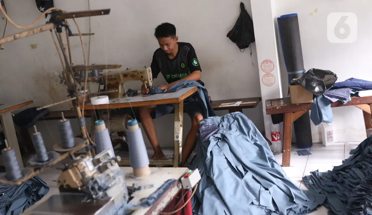 Pekerja menyelesaikan pembuatan seragam sekolah di usaha konveksi skala rumah tangga Kebayoran Lama, Jakarta, Kamis (9/7/2020). Pandemi virus corona COVID-19 berdampak pada sepinya pesanan pembuatan seragam sekolah. (Liputan6.com/Angga Yuniar)
