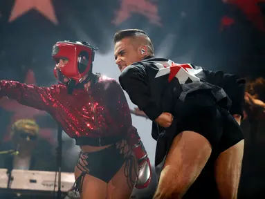 Robbie Williams tampil selama Festival Musik Corona Capital di Meksiko (17/11). Di atas panggung penyanyi Inggris ini kembali menunjukkan celana dalamnya bergambar harimau yang pernah digunakannya di video Rock DJ tahun 2000. (AP Photo/Eduardo Verdugo)