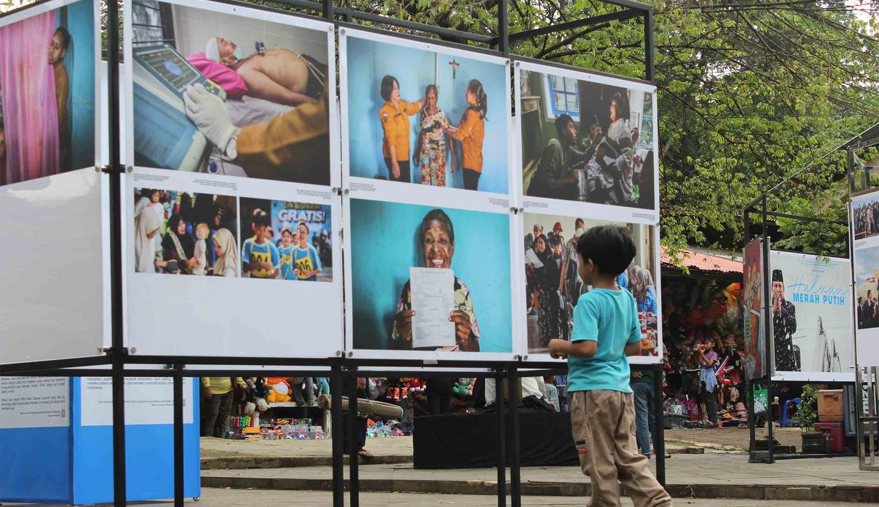 Pengunjung menyaksikan karya foto jurnalistik dalam pameran Haluan Merah Putih Roadshow yang digelar di Selasar Kantin Taman Margasatwa Ragunan, Jakarta Selatan, Rabu (24/12/2025). Kantor Berita Nasional (LKBN) ANTARA bekerja sama dengan Taman Margasatwa Ragunan menghadirkan pameran hasil karya jurnalistik. (merdeka.com/magang/Rendi Saputra)