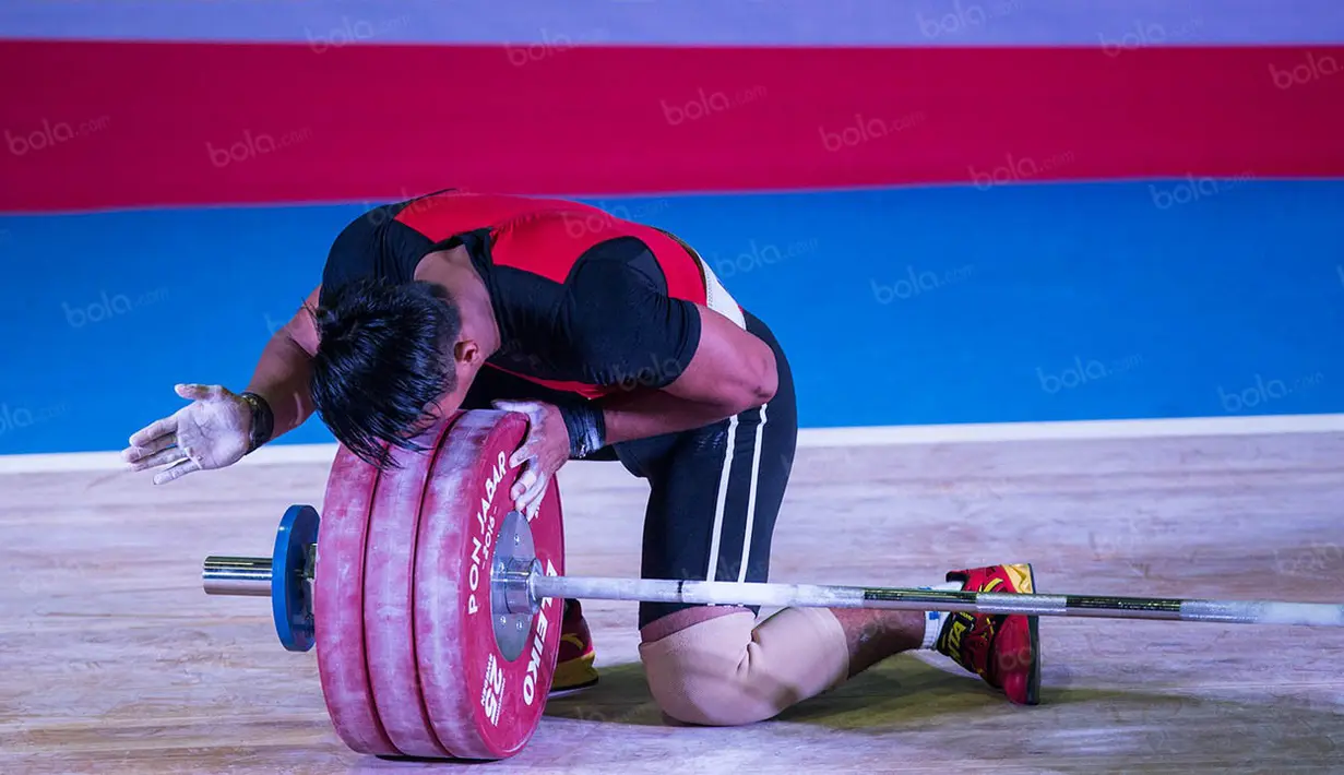 Deni mengangkat beban seberat 183 kg, memecahkan rekor PON milik Triyatno seberat 179 kg yang dibuatnya pada PON Riau 2012. (Bola.com/Vitalis Yogi Trisna)