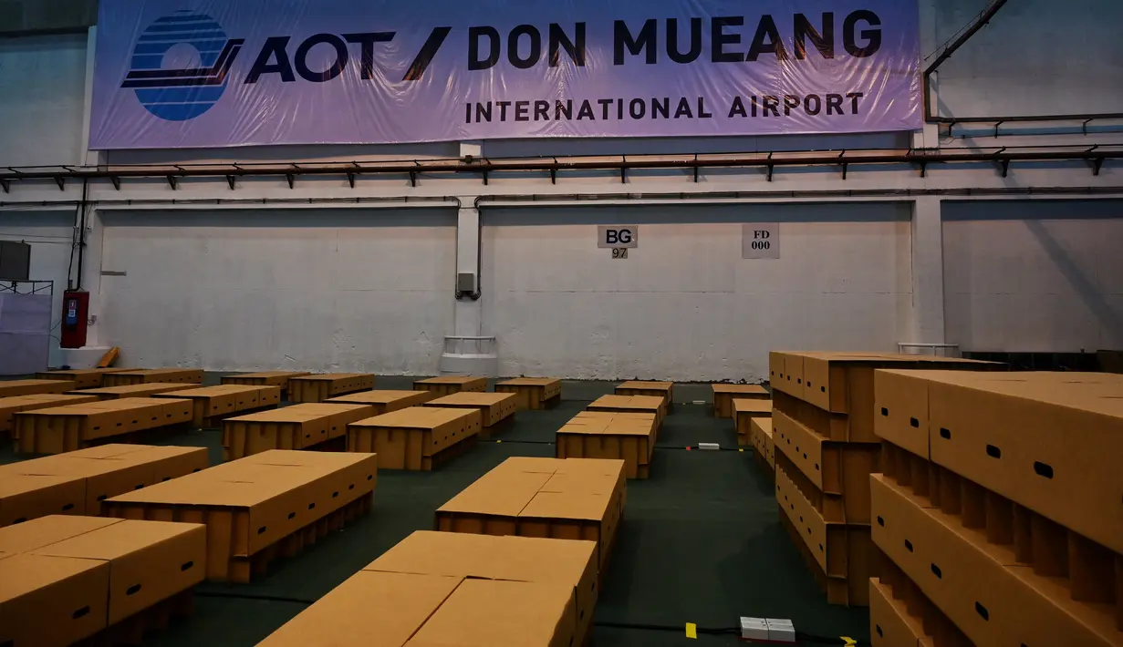 Sekitar 1.800 tempat tidur kardus disiapkan di rumah sakit lapangan Covid-19 di dalam gudang Bandara Internasional Don Mueang di Bangkok, Selasa (27/7/2021). Kasus virus corona di Thailand melonjak dan kekurangan tempat tidur untuk pasien yang terinfeksi terus terjadi. (Lillian SUWANRUMPHA/AFP)