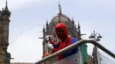 Pekerja sosial India Ashok Kurmi berpakaian seperti Spider Man mendesinfeksi daerah di sekitar stasiun kereta Chhatrapati Shivaji Maharaj selama lockdown yang diberlakukan di Mumbai, Rabu (21/4/2021). Kegiatan tersebut dilakukan untuk mengekang penyebaran COVID-19 di Mumbai. (AP Photo/Rajanish Kakad