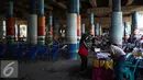 Panitia memberikan kertas suara di TPS 21 di bawah kolong jembatan tol akses Bandara, Petak Asem, Jakarta, Rabu (15/2). (Liputan6.com/Faizal Fanani)