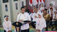 Presiden Jokowi memberikan hasil cetak foto kepada salah satu siswa pada acara penyerahan Kartu Indonesia Pintar (KIP) bagi 4.000 siswa-siswi SD, SMP, SMA se Provinsi Gorontalo di GOR David-Tonny, Gorontalo Jumat (1/3). (Liputan6.com/Arfandi Ibrahim)