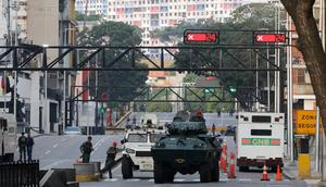 Kendaraan lapis baja Garda Nasional memblokir sebuah jalan yang mengarah ke Istana Kepresidenan Miraflores di Caracas, Venezuela, Sabtu, (3/1/2026) di tengah eskalasi ketegangan pasca penangkapan Presiden Nicolas Maduro dan istri oleh Amerika Serikat. (Dok. AP/Cristian Hernandez)