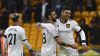 Bruno Fernandes dan Casemiro merayakan keberhasilan Manchester United (MU) meraih tiga poin di markas Wolverhampton Wanderers, Molineux Stadium, dalam laga pekan ke-18 Premier League, Sabtu (31/12/2022). MU menang 1-0 atas Wolves dalam laga itu. (AP Photo/Rui Vieira)