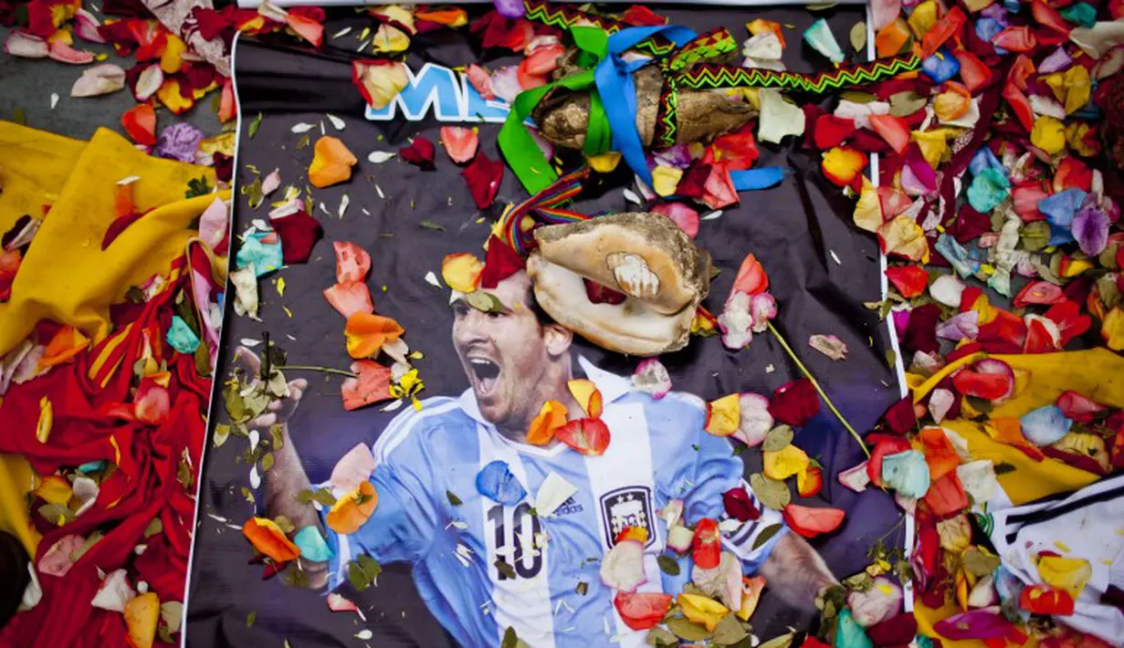 Poster Messi juga dijadikan salah satu perlengkapan dalam proses ritual yang dilakukan oleh para cenanyang Peru. Mereka berharap Messi mampu membawa argentina hingga ke final, Peru, Selasa (10/06/2014) (AFP PHOTO/ERNESTO Benavides)