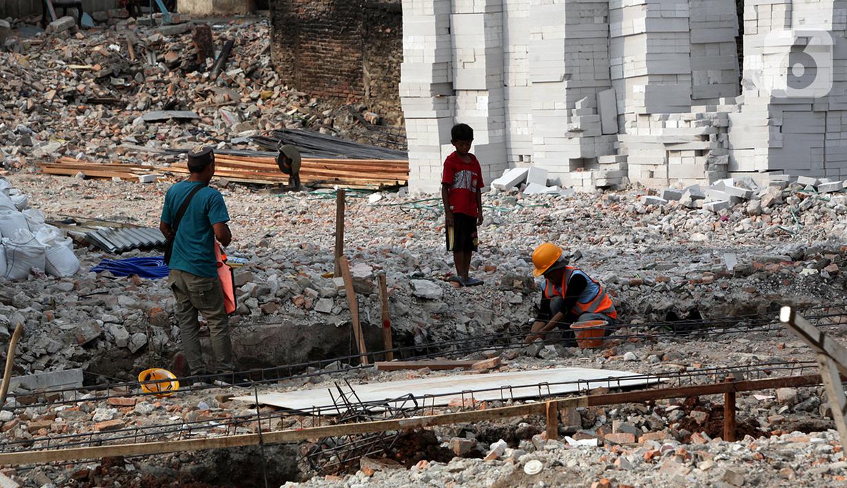 Seoranga anak mengamati pekerja di antara reruntuhan bangunan pasca kebakaran Pasar Gembrong di Cipinang Besar Utara, Jakarta, Senin (4/7/2022). Pemprov DKI Jakarta telah memulai proses revitalisasi permukiman korban kebakaran Pasar Gembrong di RW 001 yang akan diberi nama Kampung Gembira Gembrong. (Liputan6.com/Johan Tallo)