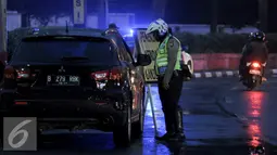 Petugas Kepolisian memberhentikan mobil yang melanggar aturan ganjil genap di Bundaran HI, Jakarta, Selasa (30/8). Sejumlah kendaraan masih didapati melanggar aturan ganjil genap yang telah resmi diberlakukan. (Liputan6.com/Yoppy Renato)