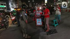 Petugas mensosialisasi aturan jam malam di sepanjang Jalan Margonda, Depok, Senin (31/8/2020). Sosialisasi aturan jam malam dilakukan selama 3 hari di kawasan Depok yang diberlakukan mulai malam hari ini guna meminimalisir penyebaran covid-19. (Liputan6.com/Herman Zakharia)