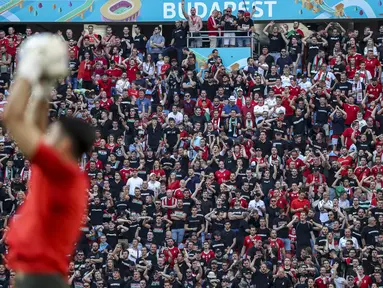 Penggemar sepak bola menghadiri pertandingan grup F Euro 2020 antara Hungaria vs Portugal di stadion Ferenc Puskas di Budapest, Selasa (15/6/2021). Pertandingan yang dimenangkan oleh Portugal 3-0 itu dihadiri lebih dari 60.000 penonton atau kapasitas maksimal Stadion. (Bernadett Szabo/Pool via AP)