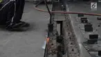 Para pekerja memperbaiki aspal di flyover Kemayoran yang mengalami kerenggangan, Jakarta, Sabtu (5/1). Hal itu disebabkan rusaknya sambungan celah sambungan alias expansion joint. (Merdeka.com/Imam Buhori)