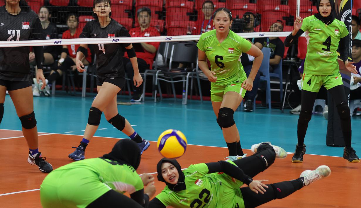 <p>Dua pemain Timnas voli putri Indonesia, Alridhania Risqamara (kanan) dan Putri Agustin berusaha menjangkau bola saat menghadapi Singapura pada laga Grup B AVC Challenge Cup 2024 di Rizal Memorial Coliseum, Manila, Filipina, Jumat (24/5/2024). Indonesia menang 3-0 (25-14, 25-13, 25-14). (Asian Volleyball Confederation)</p>