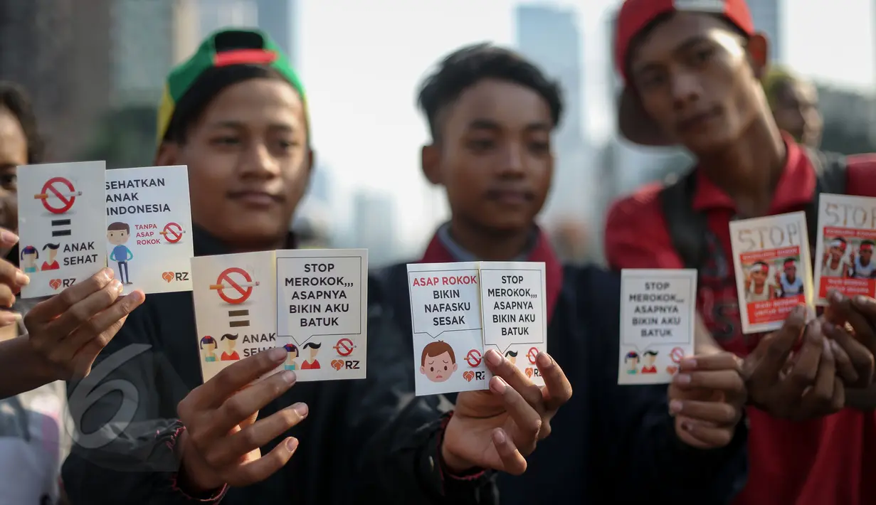 Sejumlah remaja menunjukan stiker stop merokok saat peringatan Hari Tanpa Tembakau di Bundaran HI, Jakarta, Minggu (31/5/2015). Hari Tanpa Tembakau Sedunia diperingati di seluruh dunia setiap tahun pada tanggal 31 Mei. (Liputan6.com/Faizal Fanani)