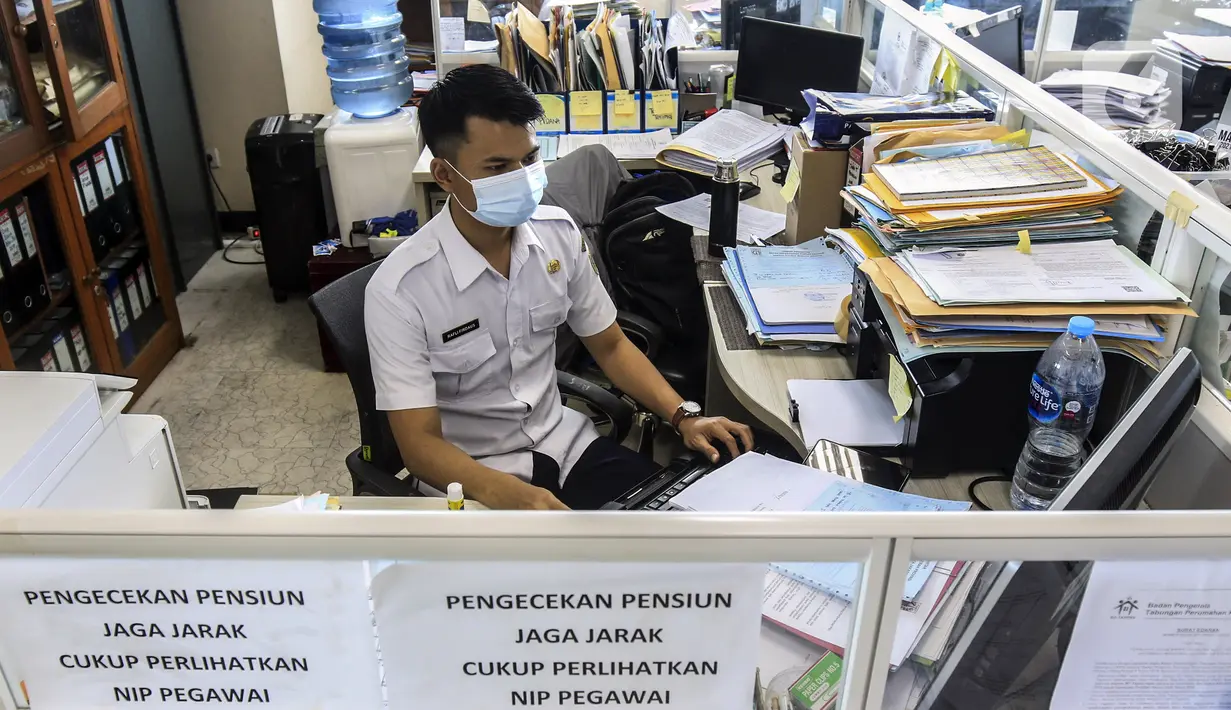 Pegawai Badan Kepegawaian Daerah DKI Jakarta menyelesaikan pekerjaannya di Kantor Balai Kota DKI Jakarta, Kamis (11/2/2021). Kementerian PANRB secara resmi melarang seluruh ASN bepergian ke luar kota saat libur Imlek guna mencegah penyebaran dan penularan COVID-19. (Liputan6.com/Johan Tallo)