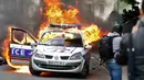 Sebuah mobil polisi terbakar saat demonstrasi buruh di Paris, Prancis (18/5). Demo buruh tersebut menentang kekerasan polisi dan melawan reformasi hukum yang berakhir bentrok dengan polisi. (REUTERS / Charles Platiau)