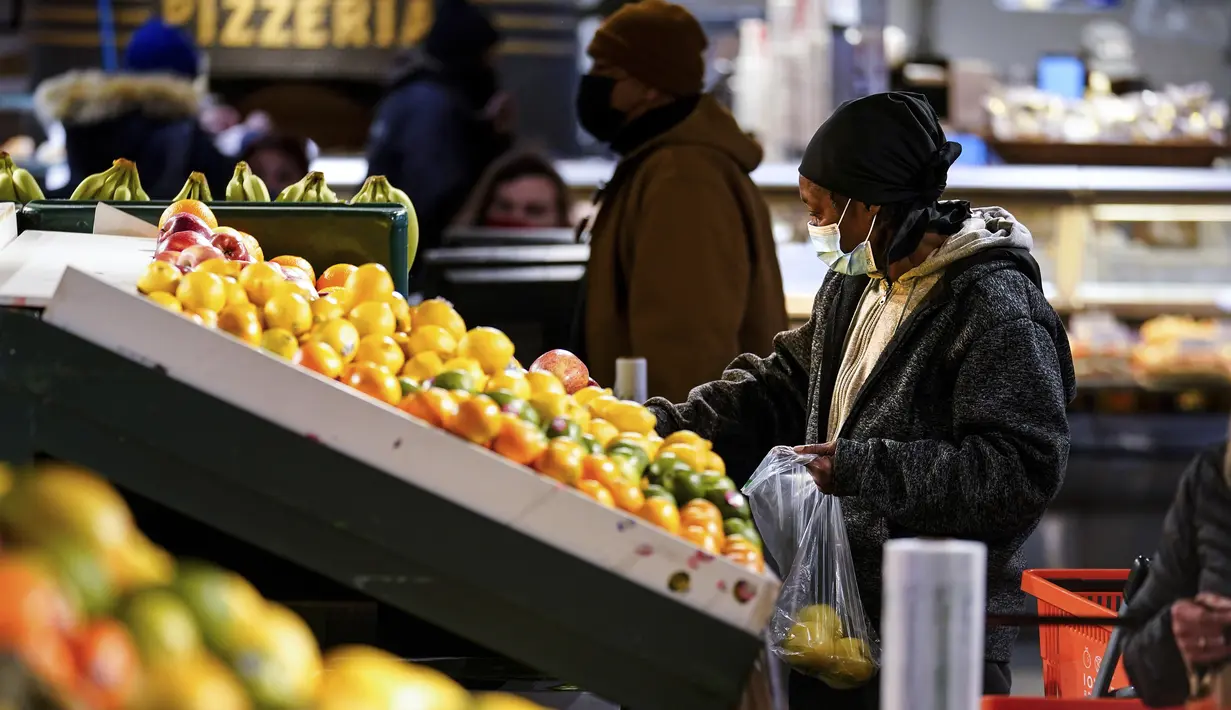 Seorang pembeli memilih buah di Reading Terminal Market di Philadelphia, Rabu (16/2/2022). Pejabat kota Philadelphia mencabut mandat vaksin untuk makan di dalam ruangan dan tempat lain yang menyajikan makanan dan minuman, tetapi mandat masker dalam ruangan tetap berlaku. (AP Photo/Matt Rourke)